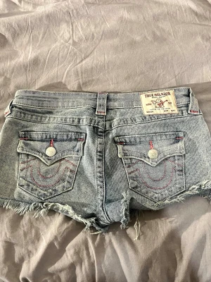 True Religion jeansshorts med rosa sömmar - Säljer ett par jätte fina slutsålda lågmidjade true religion jeans shorts i joey modellen! Super fint skick och passar jätte bra nu till sommaren💕💕 Kan skickas tidigast 6:e juni 💕