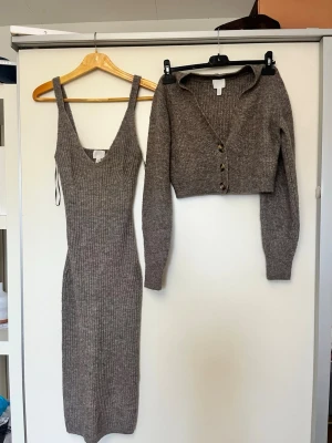 Ribbad beige stickad klänning - Säljer en ribbad, stickad klänning i beige med v-ringning och breda axelband. Klänningen är lång och har en kroppsnära passform. Perfekt för dig som gillar en enkel men snygg look. Använd 2 gånger 