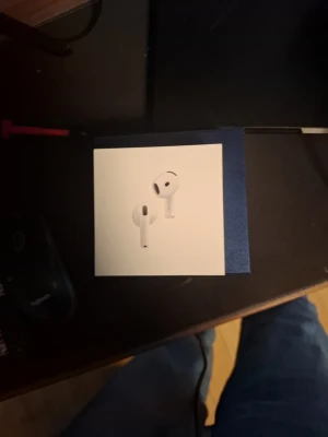 Apple AirPods 4 trådlösa hörlurar - Säljer ett par vita Apple AirPods 4 med laddningsetui. Hörlurarna är trådlösa och har en stilren, minimalistisk design i plast. Perfekta för musik, samtal och poddar med smidig anslutning till iPhone och andra Apple-enheter.