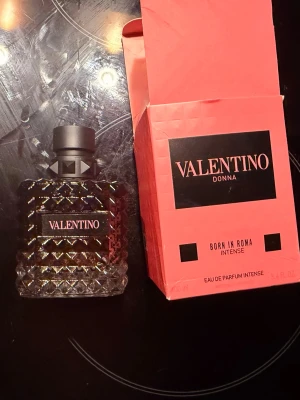 Valentino Donna parfym 100ml - Lyxig parfym från Valentino, Donna, i en elegant glasflaska med diamantmönster och svart etikett. Flaskan har en svart matt kork och kommer i en rosa kartong med svart och guld detaljer. Doften är intensiv och exklusiv.