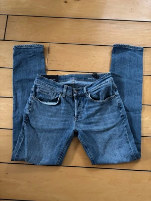 Dondup George Jeans W32  - Säljer ett par Dondup George jeans i storlek W32. Klassisk blå tvätt med snygg passform och hög kvalitet som Dondup är kända för.  Mått: • Midja: 40 cm • Ytterbenslängd: 97 cm  Jeansen är i fint använt skick. Det finns några mindre defekter/slitage, men de syns inte när jeansen sitter på och är enkla att åtgärda för den som vill.  Original Dondup George-modell med D-emblem på bakfickan och Made in Italy-kvalitet.  Skicka gärna meddelande vid frågor eller om fler bilder önskas.