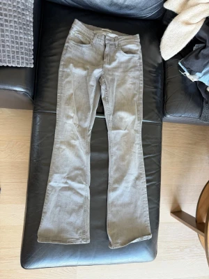 Grå bootcut jeans från Gina Tricot - Snygga gråa bootcut jeans från Gina Tricot med klassisk femficksmodell och normal midja. Jeansen har utsvängda ben och är tillverkade i ett mjukt denimtyg som ger en skön passform. Perfekta för dig som vill ha en trendig och avslappnad look.