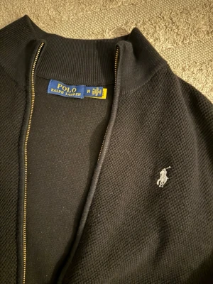 Svart ziptröja från Polo Ralph Lauren - Snygg svart ziptröja från Polo Ralph Lauren i toppskick. Bara att skriva vid frågor!