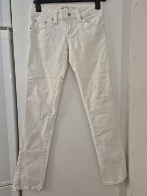 Jeansbyxor - Snygga vita jeans från ICHI med rak passform och klassisk femficksdesign. Jeansen har dekorativa sömmar på bakfickorna och silverfärgade nitar. Tillverkade i ett mjukt bomullsmaterial med lite stretch för extra komfort. Några fläckar.