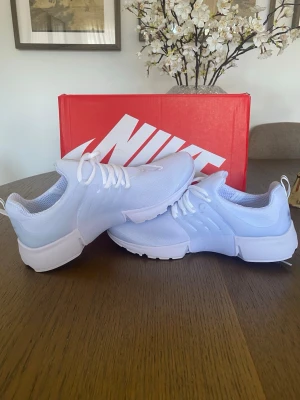 Vita Nike presto - Fräscha vita Nike sneakers med låg profil och klassisk swoosh på sidan. Ovandelen är i ventilerande mesh och sulan är i slitstark gummi. Skorna har vita snören och en modern, clean look som passar till det mesta.