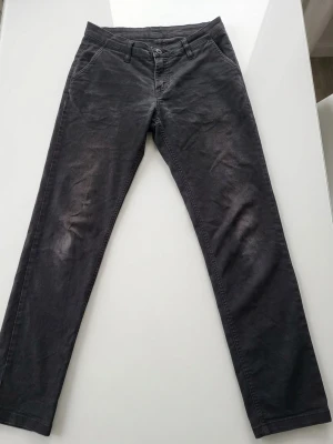 Svarta chinos från Ted Bernhardtz - Snygga svarta chinos från Ted Bernhardtz At Work, modell för kvinnor. Klassisk rak passform med fickor fram och bak. Tillverkade i mjukt och slitstarkt material som ger en bekväm känsla hela dagen.