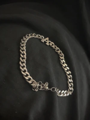 Silverfärgat armband med bokstav A - Snyggt armband i silverfärg med en kedjelänk och en hängande bokstav A som detalj. Perfekt för dig som vill ha en personlig touch på din stil. Armbandet har ett klassiskt lås och passar till många olika looks.