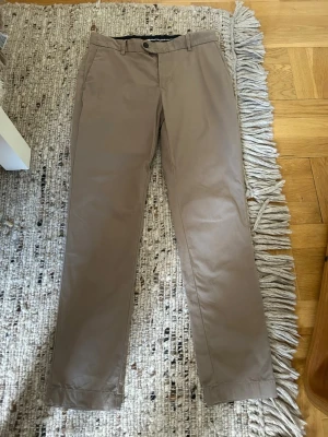 Chinos från Bläck - Snygga beige chinos med raka ben och klassisk passform.