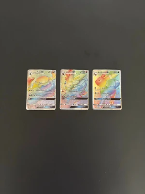 Pokémon GX Rainbow, 3st - Tre par eftertraktade rainbow GX kort. korten är i okej skick men ett par exclusiva kort som är svåra och få tag på. Dem är slitna och solblekta längst kanten och baktill men går ändå för en bra peng. Kom med bud!