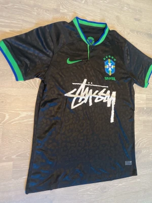 Svart Brasilien x Stüssy x Nike tröja - Säljer en svart Brasilien-tröja i samarbete mellan Nike och Stüssy. Den är i storlek M och kvaliten är helt ny. Priset kan diskuteras och skickar inom 24 Tim 