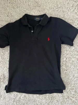  pikétröja från Ralph Lauren - Klassisk  pikétröja från Ralph Lauren med röd broderad logga på bröstet. I jättebra skick utan skador. Passar perfekt till en fräsh outfit i sommar. Storlek S💫