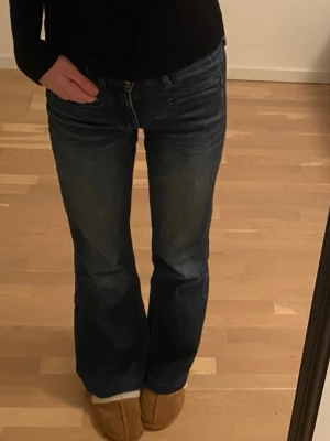 Mörkblå bootcut jeans - Säljer ett par mörkblå bootcut jeans som har låg midja, klassiska fickor fram och bak samt en snygg utsvängd passform. Mycket bra skick och super fina💗💗Storlek xs/s pris kan diskuteras
