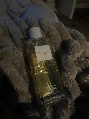 Victoria's Secret Bombshell Nights mist - Fräsch och feminin body mist från Victoria's Secret i doften Bombshell Nights. Flaskan är genomskinlig med vit etikett och vitt lock, rymmer 250 ml och har en stilren, fyrkantig form. Perfekt för dig som vill dofta gott hela dagen.