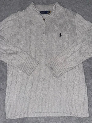 Ralph Lauren tröja - Gråa Ralph Lauren hoodie i storlek M. Ej använd, väl omhändertagen. Stilren och oerhört bekväm, funkar till allt. Säljer då den ej kom till användning. Hör gärna av dig vid frågor.  Enda defekten är att jag tyvärr klippt bort tvättlappen. Detta är vad som gäller dock:30° och fintvätt. 