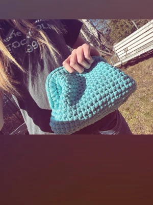 Turkos clutchbag - En handgjord turkos clutchbag i virkat tyg. Väskan har en mjuk och chunky struktur med rundad form och bred öppning upptill. Perfekt för att bära det viktigaste och ger en unik touch till din sommaroutfitt. Följ oss gärna på tiktok och insta: viraclutch🩵💞