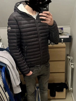 Svart dunjacka med huva från Colmar - Hej! Säljer nu min Colmar jacka, som är i riktigt fint skick! Den passar perfekt nu till våren, den är ju såklart äkta!:) Det är bara o höra av dig vid minsta fråga eller intresse!  Obs: Det är ett pyttelitet hål i jackan som är ihopsytt vilket gör att man inte märker av d alls, varken vid användning eller när du kollar på den!  Priset är inte hugget i sten!:)