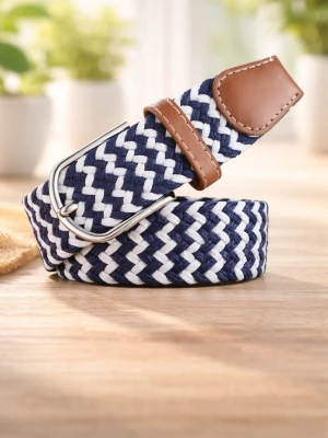 Blåvitt flätat bälte med läderdetaljer - Snyggt flätat bälte i marinblått och vitt med bruna läderdetaljer vid spännet. Bältet har ett silverfärgat metallspänne och passar perfekt till jeans eller chinos för en avslappnad men stilren look. 105cm