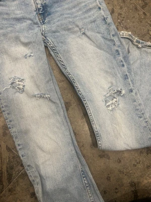 Ljusblå slitna jeans med hål - Säljer ett par ljusblå jeans med  slitningar framtill. Köpte dessa jeans på plick för ett tag sedan för 400kr, men nu säljer jag dem billigare❣️skapade även egna slitningar, jag säljer dessa jeans pga att jag knappt använder det❣️(har använt de ca 3 gånger tidigare)