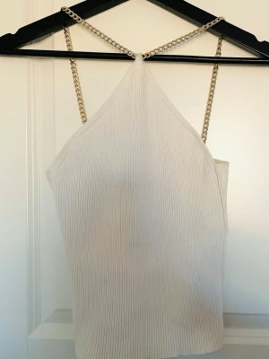 Topp/ Linne fest/ sommar - Snygg vit ribbad linnetopp med band i guldfärgad kedja säljes. Aldrig använd. Stl. xs/s