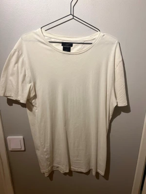 Vit t-shirt från Tiger of Sweden - Klassisk vit t-shirt från Tiger of Sweden i mjuk bomull. T-shirten har rund halsringning och korta ärmar, perfekt för en clean och enkel stil. Passar till allt och är ett måste i garderoben.