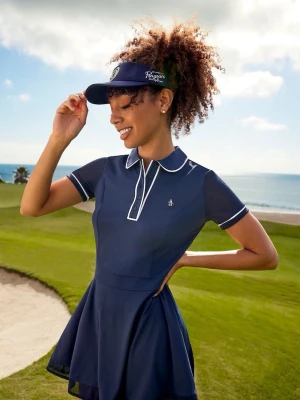 Golfklänning från original penguin  - Sportig marinblå pikéklänning från Original Penguin Veronica golf dress med vit krage och vita detaljer vid ärmslut och knappslå med medföljande shorts undertill som går att knäppa fast. Klänningen har korta ärmar, pikékrage och liten pingvinlogga på bröstet. Tillverkad i ett stretchigt syntetmaterial som ger en bekväm passform. I storlek XS, har knappt använts eftersom den var för liten. Pris kan diskuteras💕