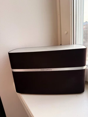 Bowers & Wilkins trådlös högtalare - Stilren trådlös högtalare från Bowers & Wilkins i svart och silver. Perfekt för att streama musik med kraftfullt ljud och snygg design som passar in i alla rum.