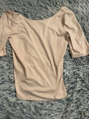 Beige topp med halvlånga ärmar - Snygg beige topp med halvlånga ärmar och bred urringning. Enkel och stilren design som passar till mycket. Tillverkad i ett mjukt och stretchigt material som sitter skönt på kroppen, rygglös. Storlek M men passar även någon i XS då då jag själv har XS! Pris kan såklart diskuteras💕