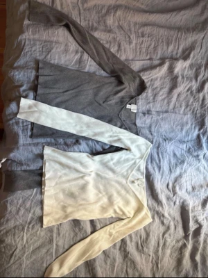 Två tröjor i grått och vitt från hm - Säljer två tröjor med V-ringning, en i grått och en i vitt. De är i storlek M men är tajta så hade också säkert kunnat passa S. Tröjorna är i nytt skick😊