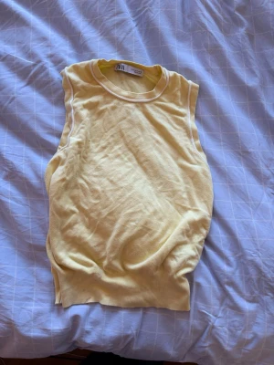 Gul ärmlös topp från Zara - Snygg gul ärmlös topp från Zara med rund halsringning och vit kant. 