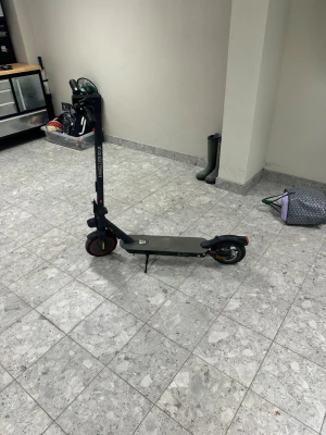 Svart elscooter med röda detaljer - Säljer en svart elscooter med röda detaljer och robust ram. Scootern har bred fotplatta, handtag med bra grepp och tydlig display på styret. Perfekt för att ta sig runt i stan på ett smidigt sätt. Laddas enkelt via eluttag.