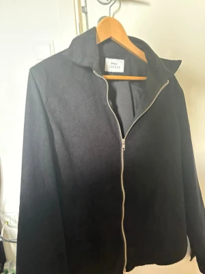 Svart overshirt Ciszere med dragkedja - Stilren svart overshirt från Ciszere med klassisk krage och silverfärgad dragkedja framtill. Overshirten är tillverkad i ett mjukt manchester tyg. Aldrig använd då den är för stor för mig. Storlek M men är lite mer åt L skulle jag säga. 