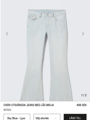 Ljusblå utsvängda jeans Monki aldrig använd/prislapp kvar  - Säljer ett par ljusblå utsvängda jeans från Monki med låg midja. Jeansen har klassisk femficksdesign, synliga gula sömmar och knapp med Monki-logga. Perfekta för dig som gillar retrovibbar och relaxed stil.