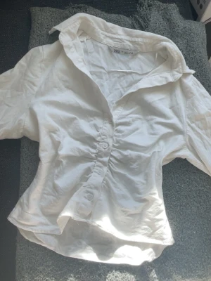 Vit skjorta zara - Så fin vit skjorta med scrunch framtill. Den är i storlek L men passar som en xs/s! Säljer då den inte passade, nytt skick.🌸