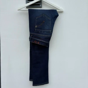 Dondup George - Tjena! Mörkblåa jeans från märket Dondup i modellen: ”George”. Deras mest populära modell och marknadens hetaste jeans just nu. (Size: 31)  (Skick: 5/5)  (Retail: 3500kr)  (Vårt pris: 799kr). (Mått: A = 39cm, B = 24cm, C = 77cm). Hör av er vid frågor & funderingar! /Mvh, Morëtti Co.