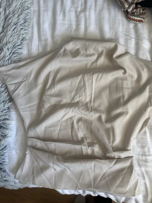 Beige kortärmad blus i bomull - Stilren beige blus med korta ärmar och rak passform. Tillverkad i mjukt bomullstyg, perfekt för en enkel och clean look. Passar till många olika outfits och är lätt att matcha med andra plagg.