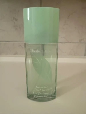 Elizabeth Arden Green Tea parfym 100 ml - Fräsch parfym från Elizabeth Arden i doften Green Tea. Flaskan är grön och genomskinlig med ett stilrent bladmotiv och ett matchande grönt lock. Innehåller 100 ml Eau de Toilette Spray. Perfekt för dig som gillar lätta och uppfriskande dofter.