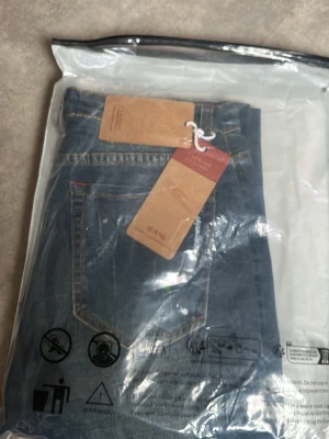 Blå raka jeans från Levi's - Säljer ett par klassiska blå jeans från Levi's med raka ben och normalhög midja. Jeansen har tydliga kontrastsömmar och bakficka med den ikoniska röda Levi's-lappen. Perfekta för en avslappnad och stilren look. Aldrig använt pris går och diskutera 