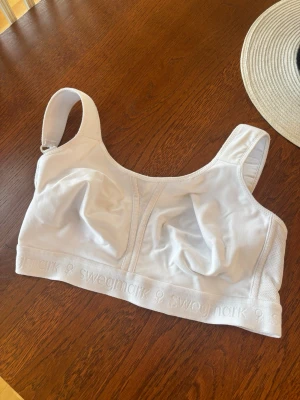 Vit mjuk bh från Swegmark - Säljer en vit, mjuk och skön bh från Swegmark med breda axelband och utan bygel. Bh:n har en sportig look och är tillverkad i ett stretchigt material med diskret logga på resåren. Perfekt för dig som vill ha komfort och stöd i vardagen.
