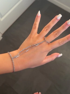 Silver hand chain from By Sofia Wistam  - Säljer mitt custom silver hand chain från By Sofia Wistam i indisk stil. Använt ca 2 månader i mycket bra skick utan rost eller färgförändring, även vid dusch och daglig användning. Köpt för 2995 SEK (ca 280 USD), säljs pga jag hittat ett annat smycke. Passar handled ca 15,5–17 cm (min är 16 cm). Fingerskedjan passar ringstorlek ca 5–7 i diameter. Ingen originalförpackning. Pris kan diskuteras❤️Smycket förstörs inte av vatten. Kedjan mellan finger och handled är 17 cm😍