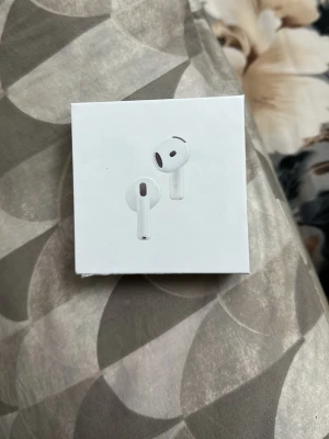 Apple AirPods 4 med brusreducering - Säljer ett par vita Apple AirPods 4 med aktiv brusreducering. Trådlösa in-ear hörlurar med laddningsetui, kompatibla med USB-C. Snygg och stilren design i plast, perfekt för musik och samtal. (Inte äkta men funkar precis som ett par äkta)