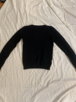 Svart stickad tröja med rund hals - Svart stickade tröja som är lite kortare och tajt men också stretchig men den är väldig skön och snygg och passar till mycket  den är i storlek s men skulle mer säga att den är som en Xxs/xs 