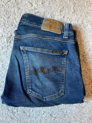 Nudie Jeans  - Säljer ett par Nudie jeans med snygg wash i mörkblå färg , jeansen är i väldigt fint skick och har inte använts på flertalet månader 