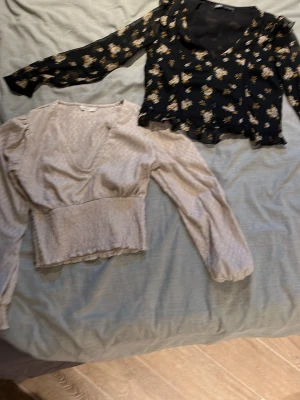 Två blusar  - Två v-ringa blusar en begie och en blommig i storlek s och xs men liknar båda mer xs hör av er om ni bara vill ha en pris kan diskuteras