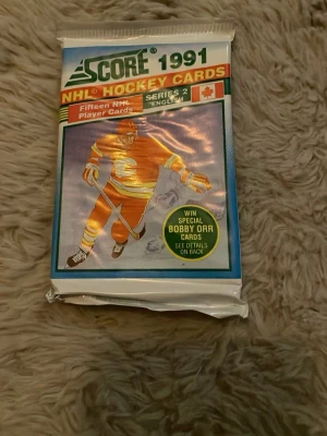 NHL Hockeykort Score 1991 Series 2 - Oöppnat paket med NHL hockeykort från Score, år 1991, Series 2. Förpackningen innehåller femton spelarkort och har färgerna blå, vit, röd och gul. Perfekt för samlare eller hockeyfans som gillar retroprylar.