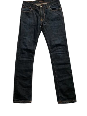 Nudie Jeans - Snygga mörkblå jeans från Nudie Jeans i mycket fina skick! Perfekta för en stilren och avslappnad look. Jeansen är i W32 L32 och är slim fit! Hör av dig vid frågor, Sbstyle:)