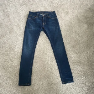 Nudie jeans 28/30 - Säljer dessa nudie jeans i modellen ”Tight Terry”-slim fit. färgen heter ”dark steel”. Dessa är i storlek 28/30 och är knappt använda. Skick 9/10. Liten fläck på vänster knäväck.