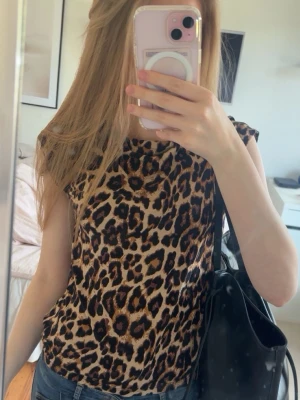 Leopardmönstrad ärmlös topp - Cool topp med leopardmönster och korta ärmar. Modellen är rak och passar perfekt till jeans eller kjol. Toppens material känns mjukt och lätt, vilket gör den skön att bära hela dagen.Slutåld på lager 157💕🐆