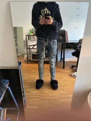 Slim fit ljusblå purple jeans jeans med snörning - Säljer ett par slim fit ljusblå jeans med slitningar och snörning i midjan. Jeansen har en tvättad look och smala ben som sitter tajt hela vägen ner. Perfekta för dig som gillar streetwear och en avslappnad stil.