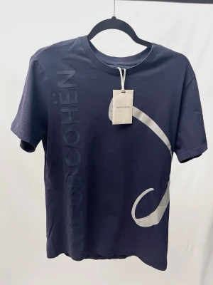 Jacob Cohën Tshirt - Riktigt stilren och unik tshirt från det exlusiva märket Jacob Cohën! Helt ny med tags. Storlek M, sitter normalt. Kontakta mig för fler frågor och funderingar!
