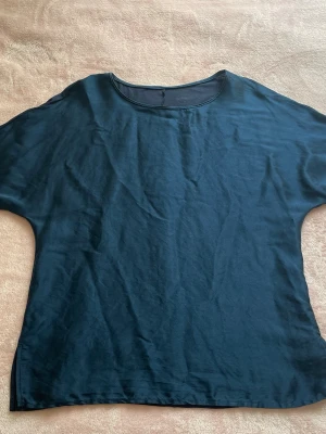 Blå silkeströja från Intimissimi i S - En enkel och stilren blå tröja från Intimissimi i storlek S. T-shirten har rund halsringning, korta ärmar och flowing passform. Framsidan är tillverlad av silke, och baksidan är intimissimis vanliga mjuka modal material. Skulle beskriva färgen som ”royal blue.” Lappen går att skanna, se de sista två bilderna. 